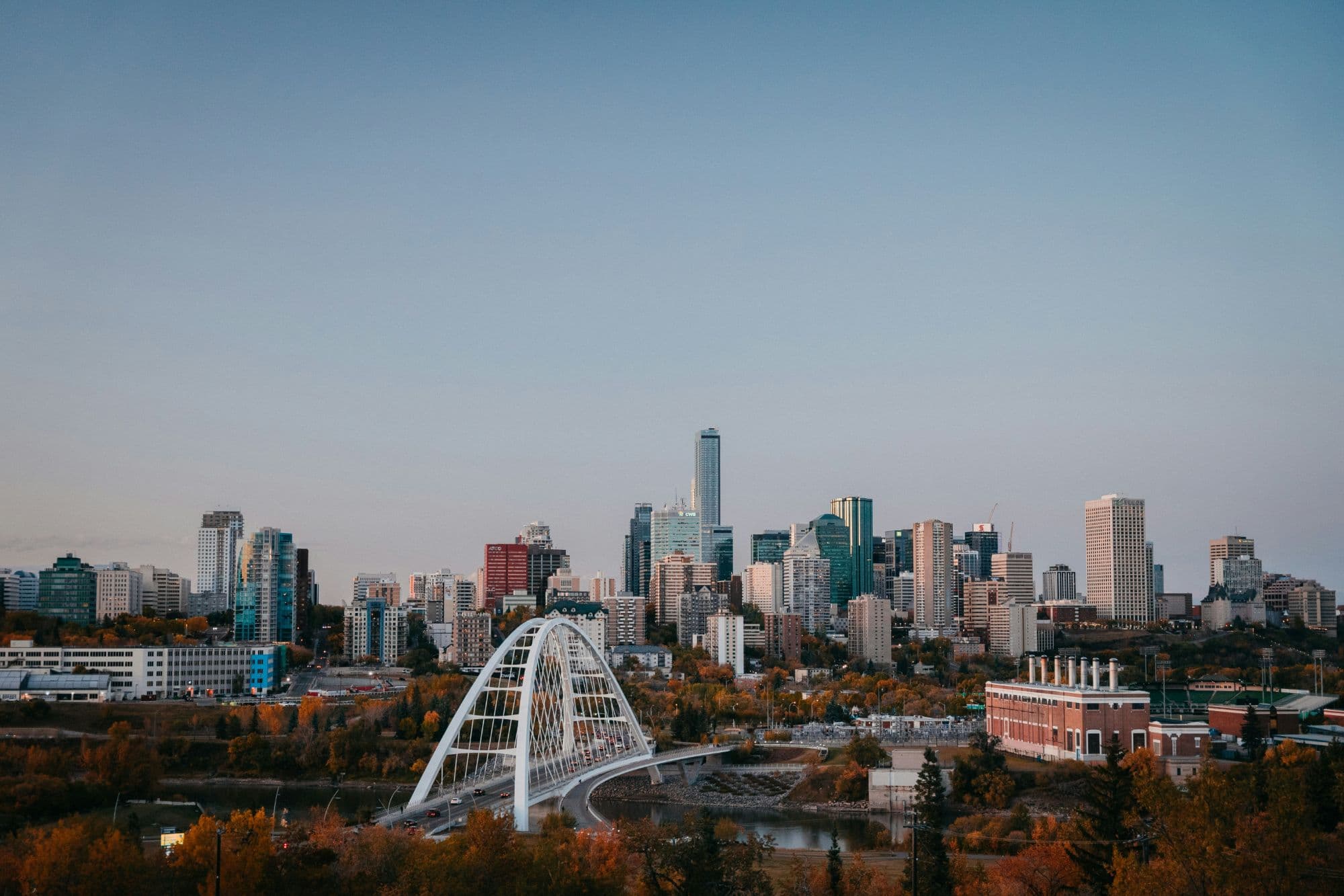 Downtown Edmonton and the white arch of the Walterdale Bridge over the North Saskatchewan River, with fall colour in the river valley
